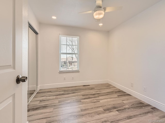 unfurnished bedroom with recessed lighting, a closet, a ceiling fan, wood finished floors, and baseboards