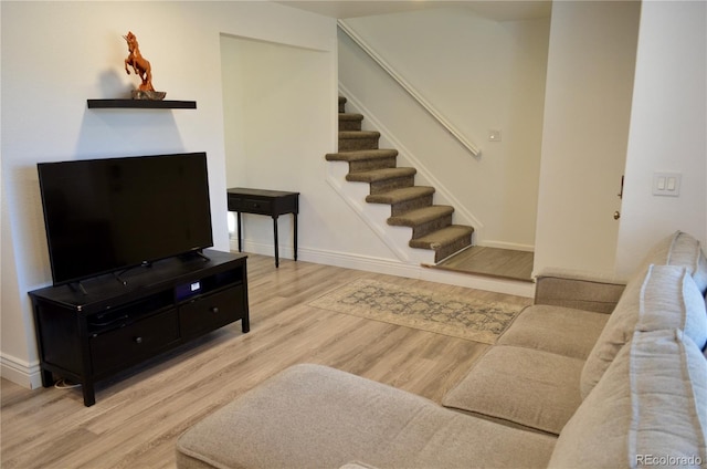 living room with stairway, wood finished floors, and baseboards