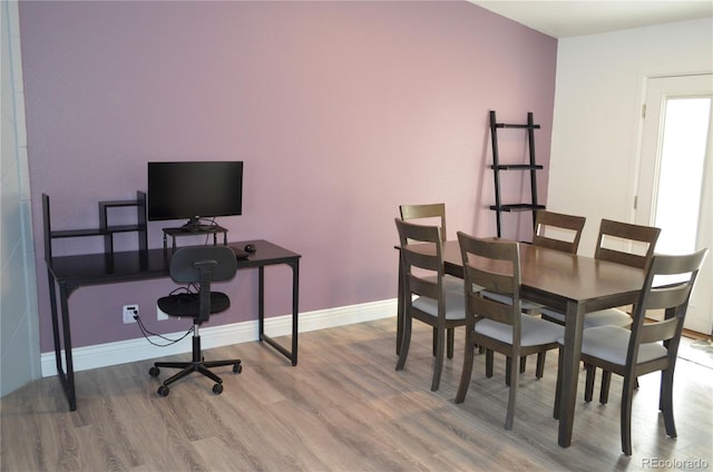 dining area with baseboards and wood finished floors