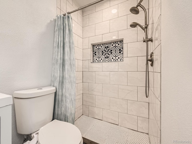 full bathroom featuring a textured wall, a tile shower, and toilet