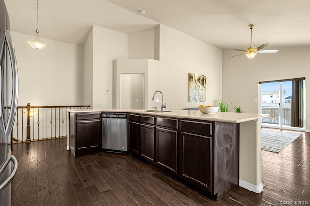 kitchen featuring a sink, dark wood finished floors, appliances with stainless steel finishes, light countertops, and dark brown cabinets