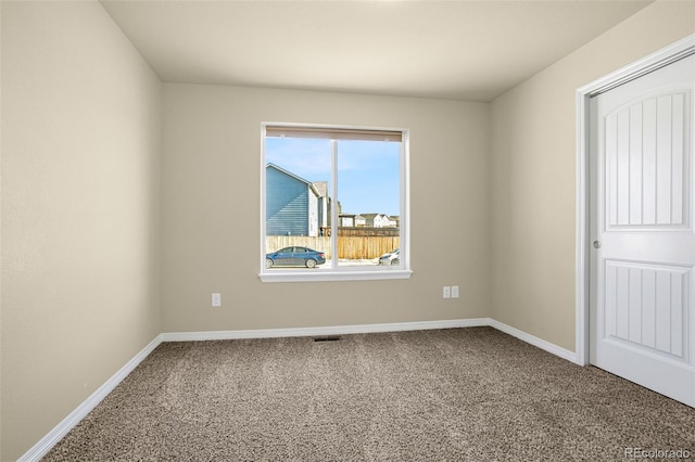 empty room with visible vents, carpet, and baseboards