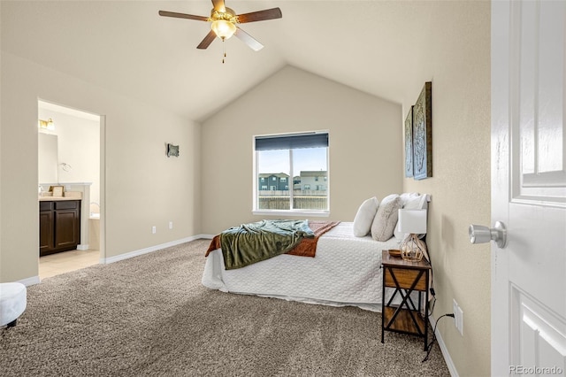 bedroom featuring a ceiling fan, baseboards, ensuite bath, vaulted ceiling, and light colored carpet