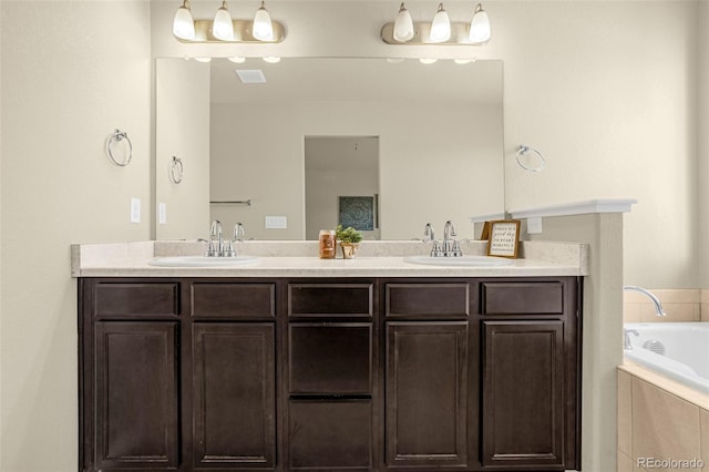 bathroom with double vanity, a tub to relax in, and a sink