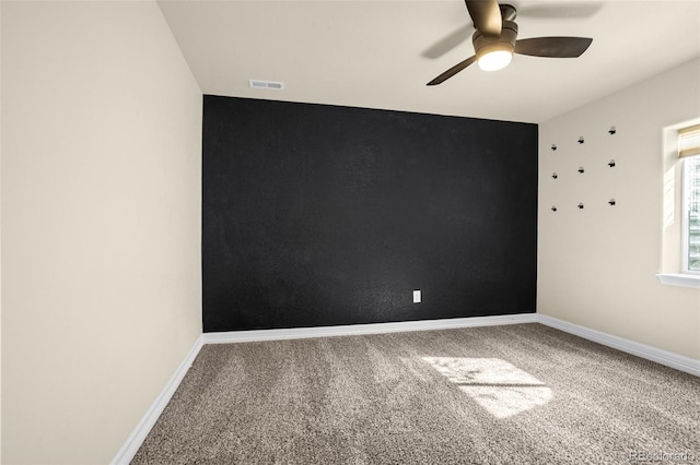 spare room with visible vents, baseboards, carpet, and ceiling fan