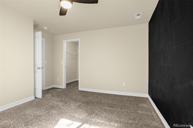 unfurnished bedroom with baseboards, visible vents, carpet floors, a spacious closet, and a closet