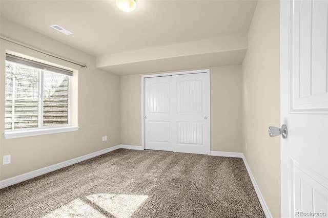 unfurnished bedroom with a closet, visible vents, baseboards, and carpet floors