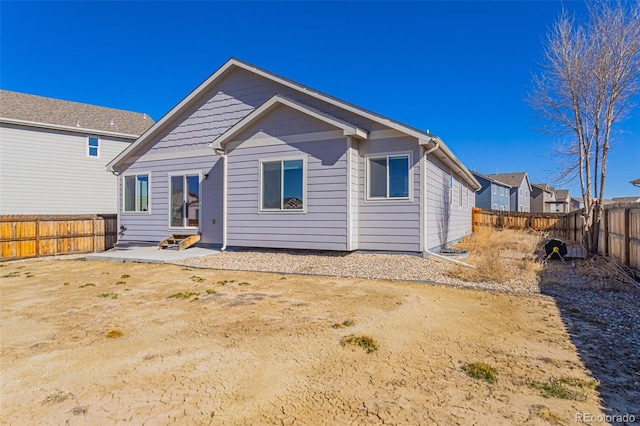 back of property featuring a fenced backyard and entry steps