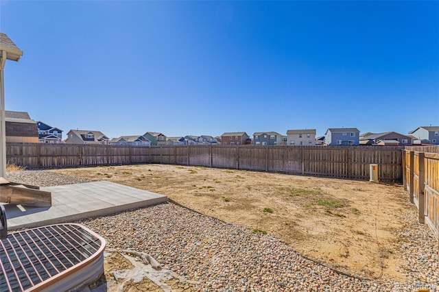 view of yard featuring a patio area, a residential view, and a fenced backyard