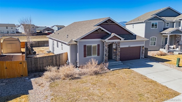 view of front of property with fence, a shingled roof, concrete driveway, a garage, and a residential view