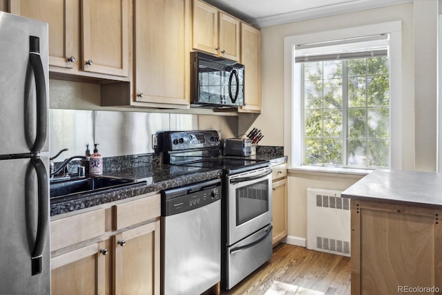 1450 Albion St Unit 206, Denver, CO 80220 - kitchen with appliances with stainless steel finishes, radiator heating unit, light wood finished floors, light brown cabinets, and dark countertops