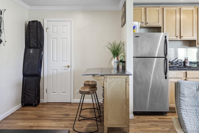 1450 Albion St Unit 206, Denver, CO 80220 - kitchen with freestanding refrigerator, crown molding, wood finished floors, and light brown cabinetry
