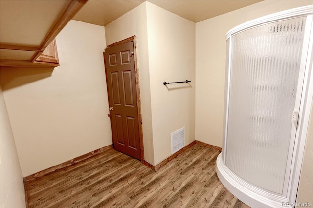 bathroom featuring hardwood / wood-style flooring and a shower with shower door