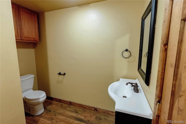 bathroom featuring vanity, hardwood / wood-style flooring, and toilet