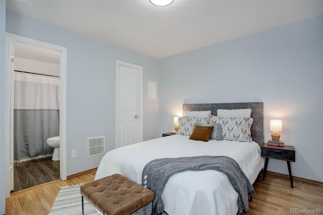 bedroom with wood-type flooring and ensuite bathroom