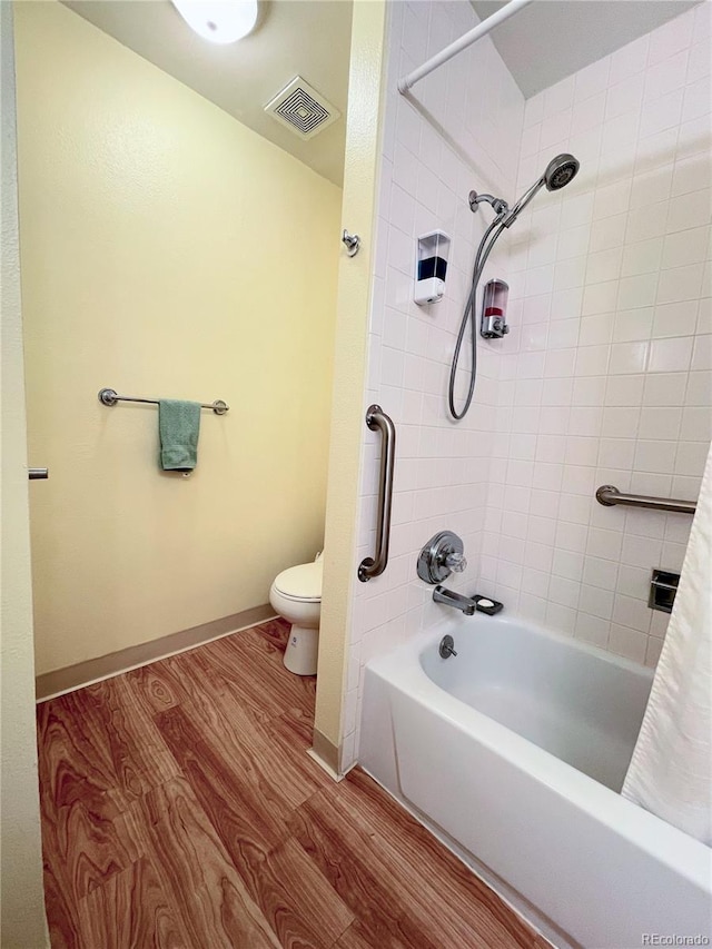 bathroom with wood-type flooring, shower / bath combination with curtain, and toilet