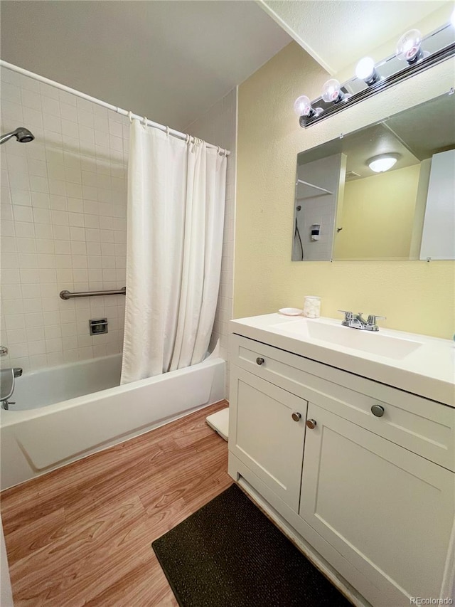 bathroom featuring wood-type flooring, shower / bath combo, and vanity