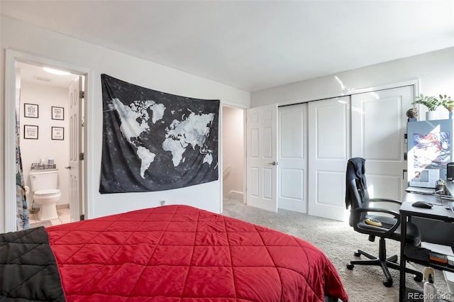 carpeted bedroom featuring ensuite bath and a closet