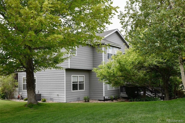 view of property exterior featuring central AC and a yard