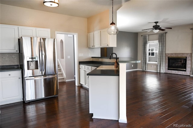 kitchen featuring sink, stainless steel refrigerator with ice dispenser, ceiling fan, decorative light fixtures, and white cabinetry