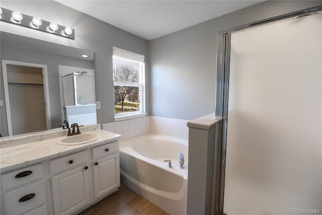 bathroom featuring vanity and independent shower and bath