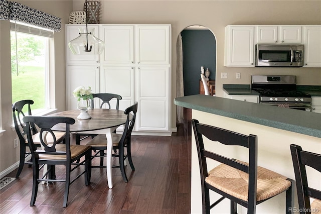 dining space with dark wood-type flooring and an inviting chandelier