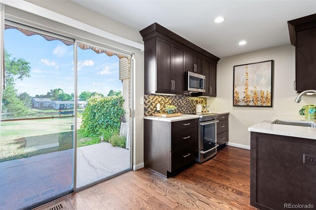 4452 W Pondview Dr, Littleton, CO 80123 - kitchen with stainless steel appliances, dark brown cabinets, light countertops, dark wood-style floors, and backsplash