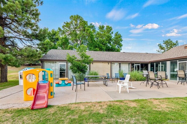 4452 W Pondview Dr, Littleton, CO 80123 - back of property featuring a patio area, a lawn, and roof with shingles