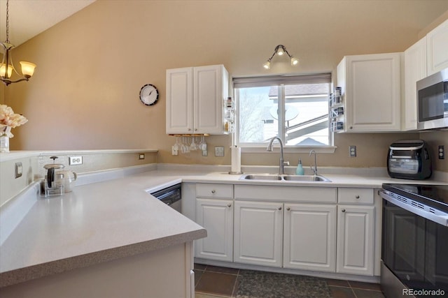 kitchen with a sink, stainless steel appliances, light countertops, and white cabinetry