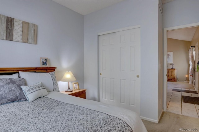 carpeted bedroom featuring a closet and baseboards