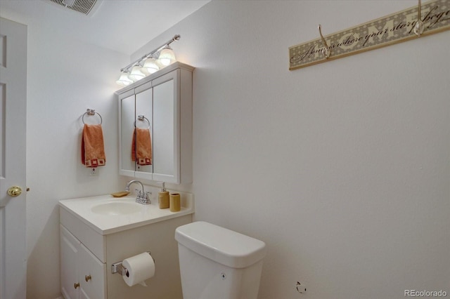 bathroom featuring visible vents, toilet, and vanity