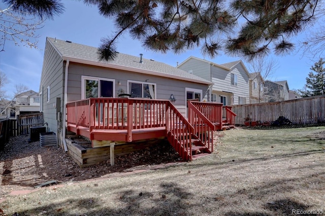 back of house with cooling unit, fence, roof with shingles, a wooden deck, and a yard