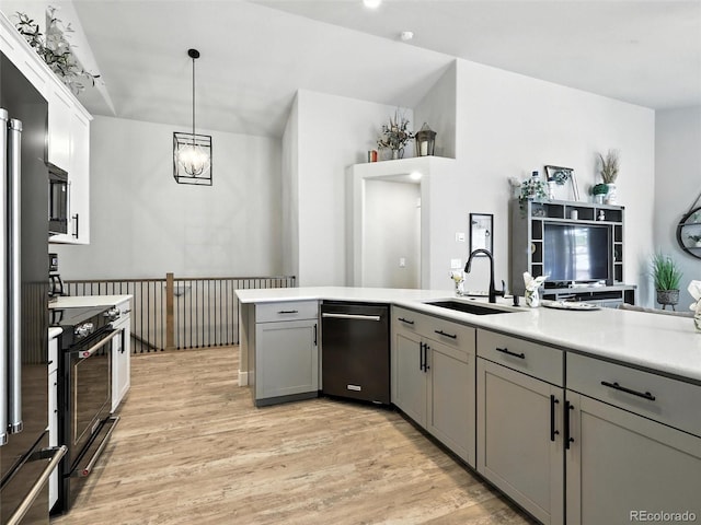 kitchen with appliances with stainless steel finishes, gray cabinetry, light wood-type flooring, and light countertops