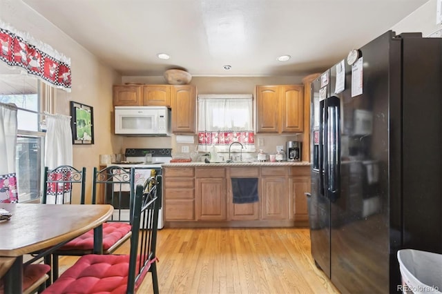 kitchen featuring white appliances, light hardwood / wood-style flooring, and sink