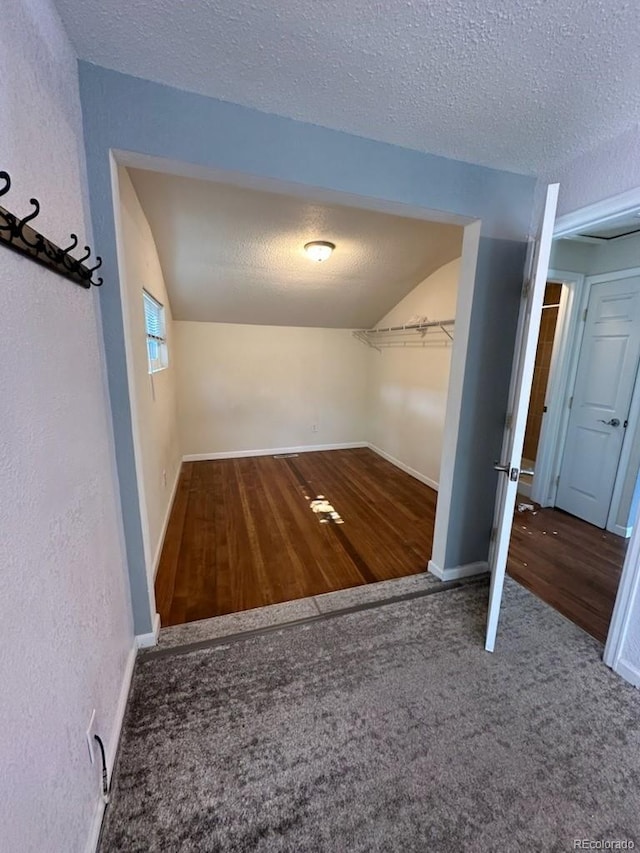 3656 W 77th Ave, Westminster, CO 80030 - corridor featuring a textured ceiling, vaulted ceiling, carpet, and wood finished floors