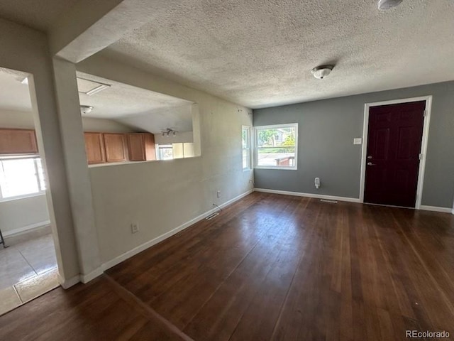3656 W 77th Ave, Westminster, CO 80030 - unfurnished living room with dark wood-type flooring and a textured ceiling