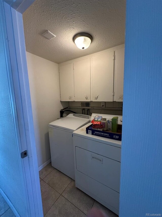 3656 W 77th Ave, Westminster, CO 80030 - laundry room with cabinet space, washing machine and clothes dryer, light tile patterned floors, and a textured ceiling