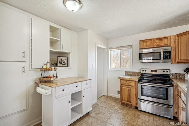 kitchen featuring stainless steel appliances, light countertops, a textured ceiling, and open shelves