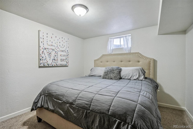 carpeted bedroom featuring baseboards and a textured wall