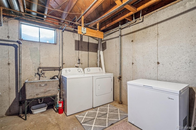 laundry room with laundry area, a sink, and washing machine and clothes dryer