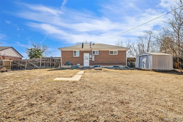 rear view of property featuring an outbuilding, brick siding, a fenced backyard, and a shed