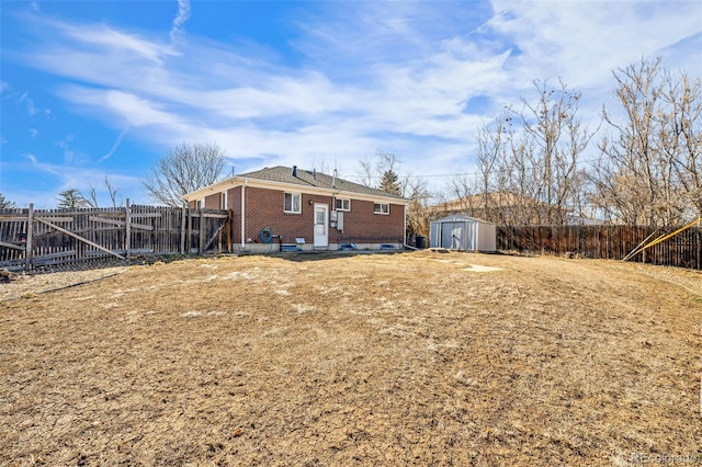 rear view of property with a shed, fence, an outdoor structure, and brick siding