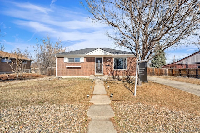 bungalow-style home with brick siding and fence