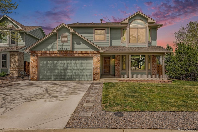 traditional home with a porch, brick siding, a yard, and driveway