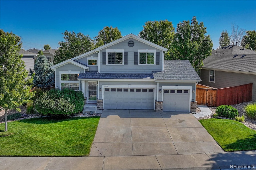 front of property with a garage and a front lawn