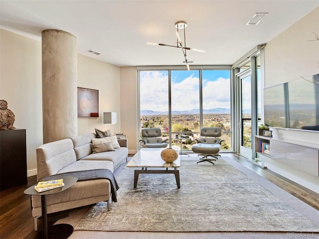 living room with hardwood / wood-style flooring, expansive windows, a mountain view, and a notable chandelier