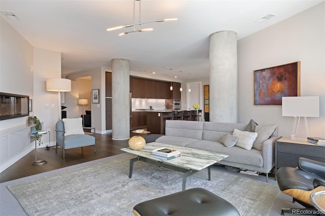 living room with dark hardwood / wood-style flooring and a chandelier