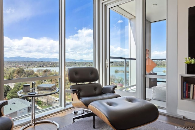 sitting room featuring hardwood / wood-style floors and a water and mountain view