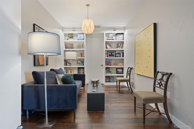 sitting room featuring built in features and dark wood-type flooring