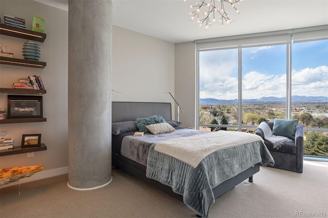 carpeted bedroom featuring a mountain view and a wall of windows